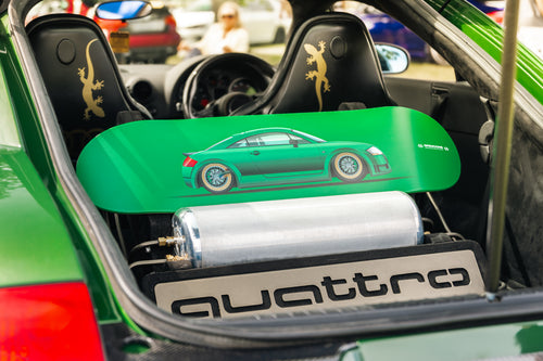 Green car interior with a green skateboard deck featuring a car design and 'quattro' branding.