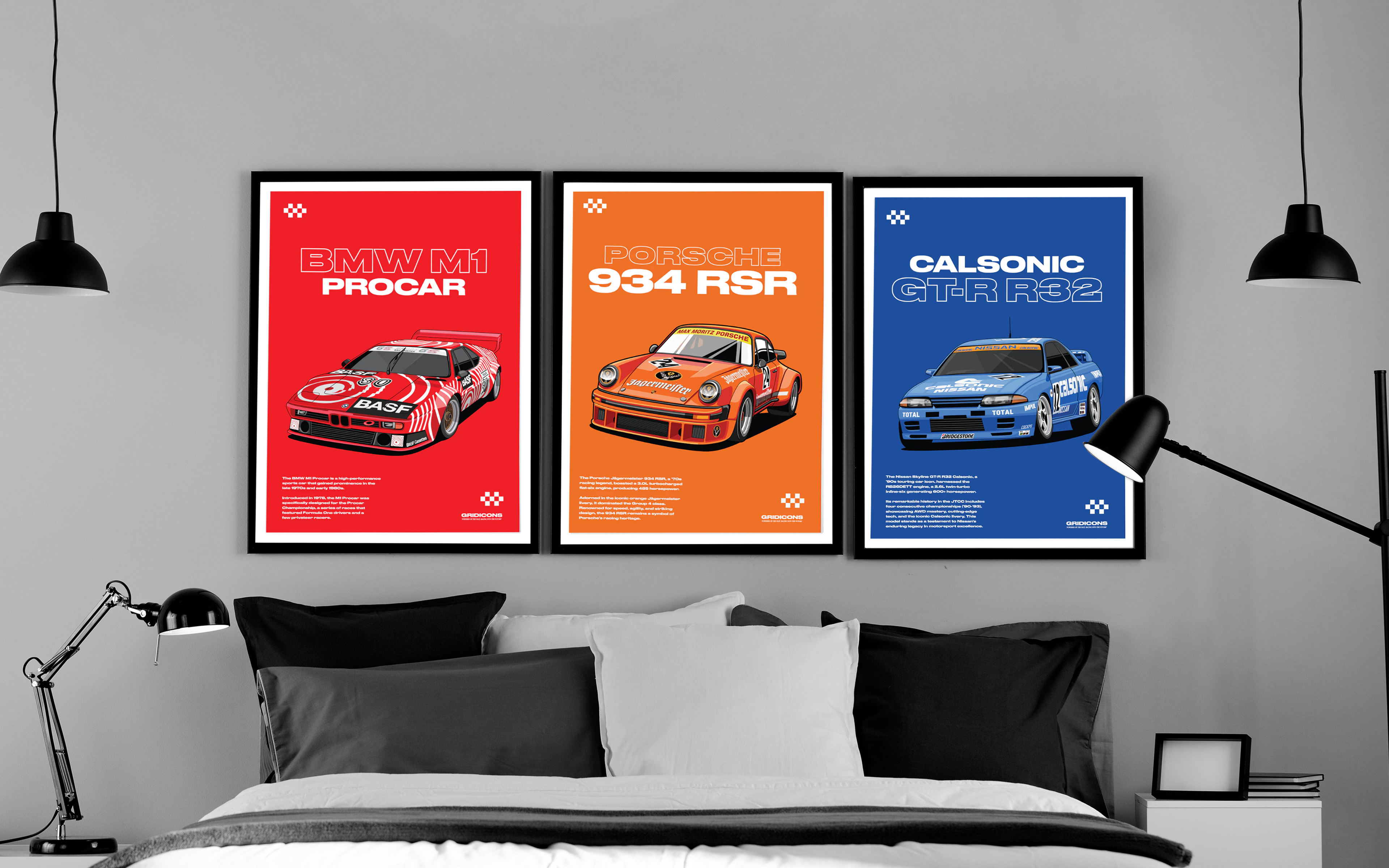 Three framed car posters on a wall above a bed.